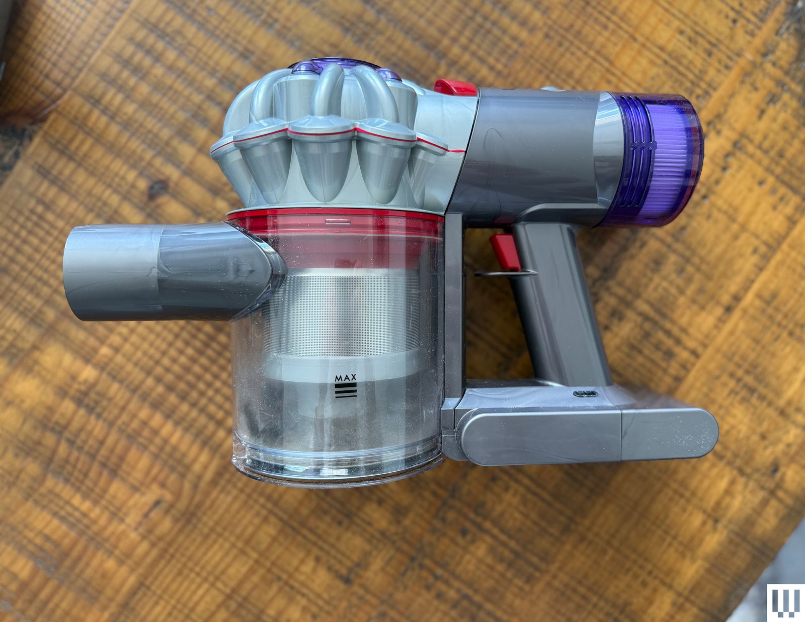 Overhead view of Dyson CarBoat Handheld Vacuum on top of a wooden table.